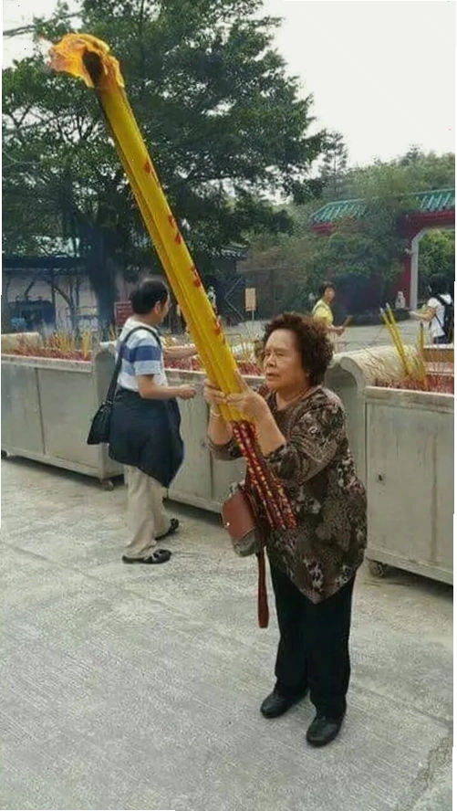 Ảnh meme người bà lớn tuổi vác cây nhang vàng khổng lồ