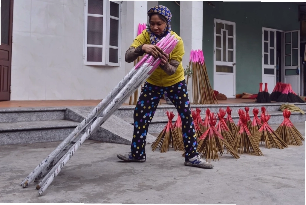 Người thợ đang quết bột nhang lên cốt cây Điền thanh
