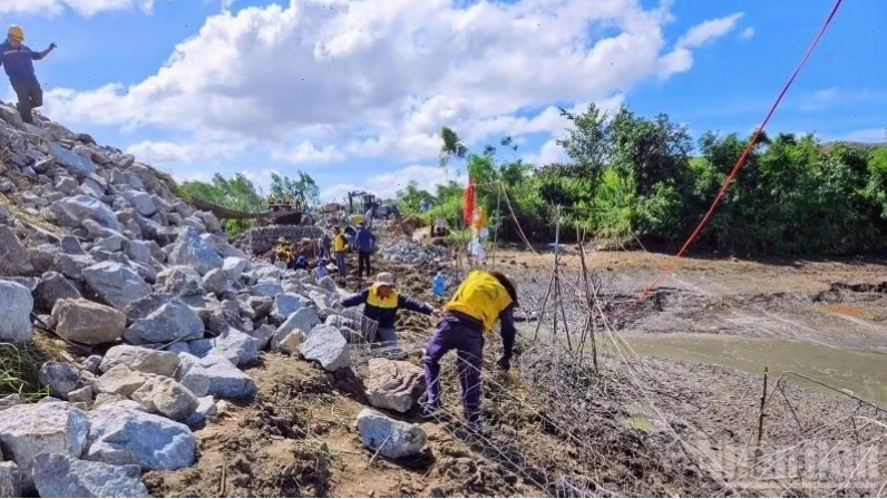 Lực lượng công nhân giao thông dọn dẹp cây đổ và cột điện gãy để thông đường